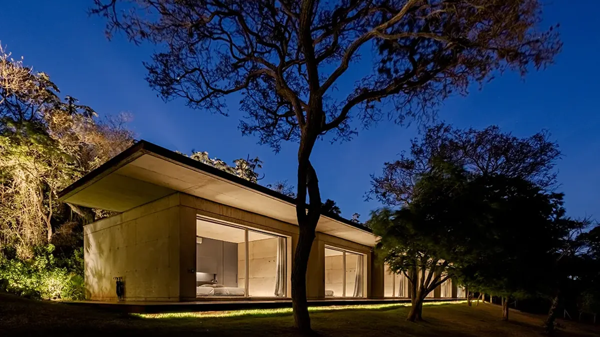 Residência contemporânea com iluminação arquitetural automatizada nas áreas internas e externas
