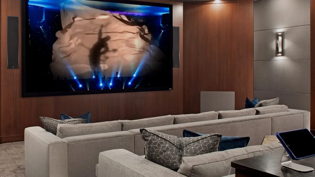 Home theater com painéis revestidos, carpete, estofados e materiais acústicos integrados