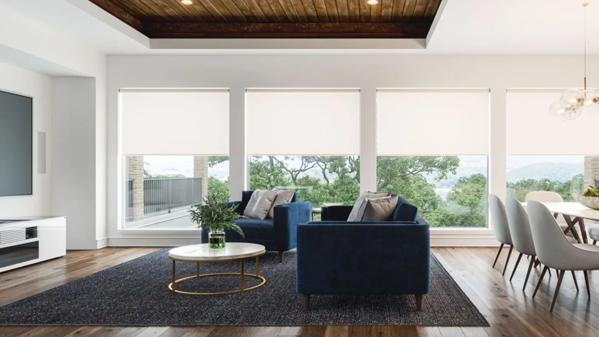 Sala residencial com persianas motorizadas controlando a entrada de luz natural