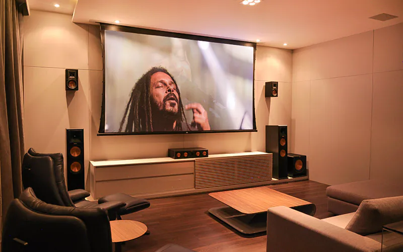 Sala de home theater automatizado com tela de projeção e sistema de áudio