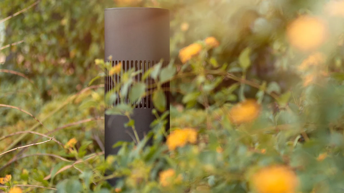 Caixa de som externa discretamente camuflada entre flores e folhagens