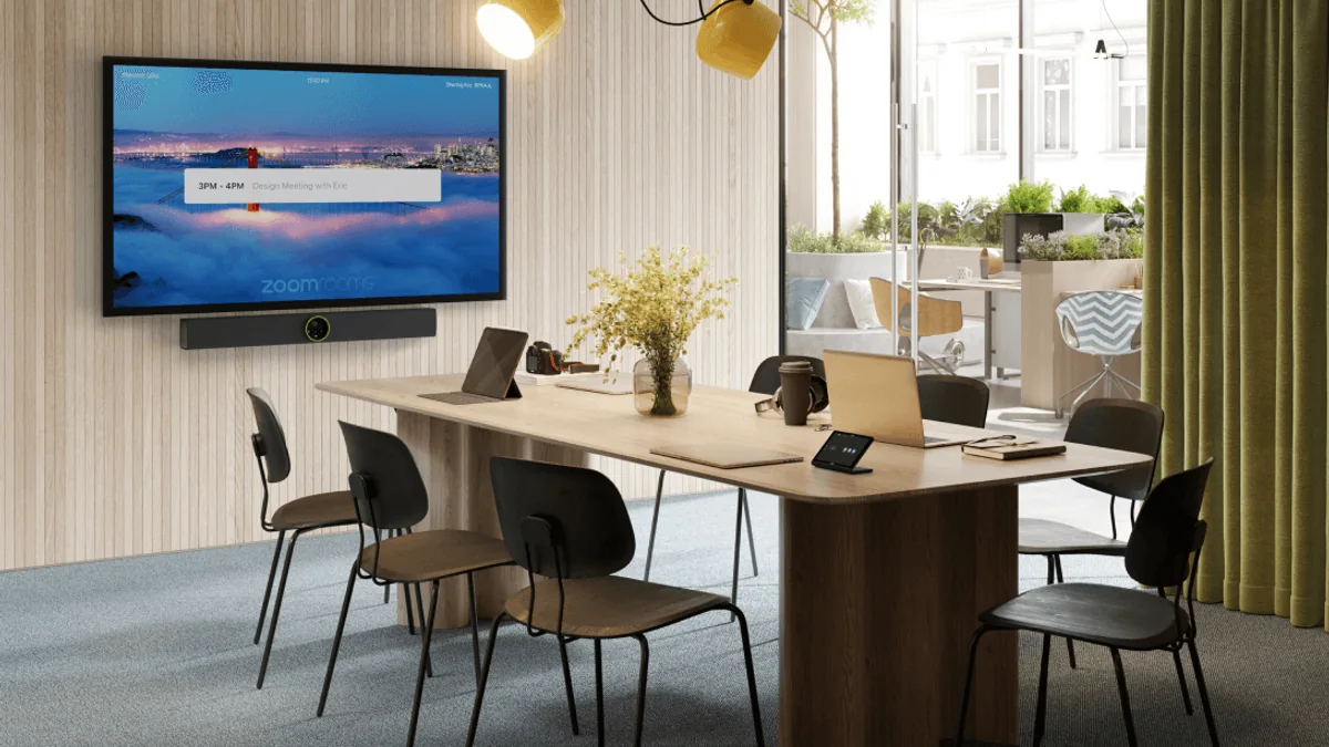 Sala de reunião equipada com câmera, microfone e soundbar de videoconferência