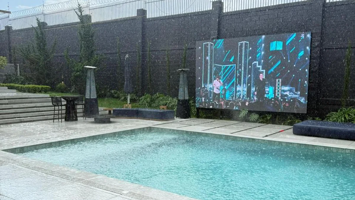 Painel de LED outdoor funcionando durante a chuva em uma área externa com piscina