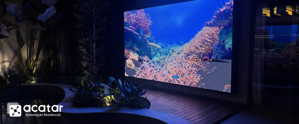 Painel de LED instalado ao lado de uma piscina residencial durante a noite