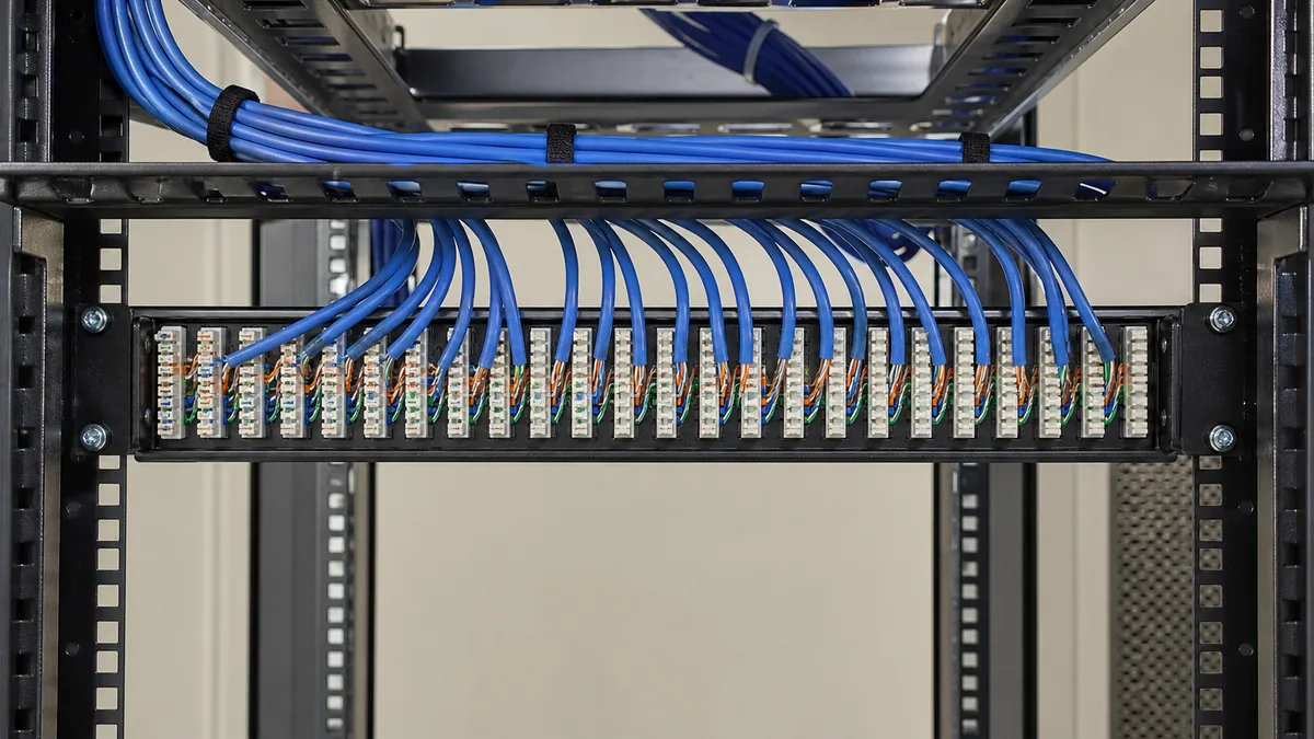 Cabos azuis organizados e terminados em blocos IDC na traseira de patch panel
