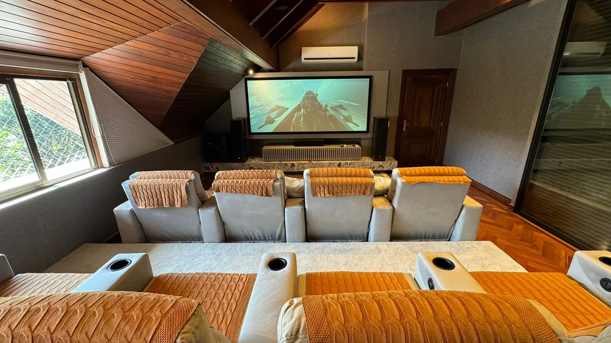 Sala de cinema residencial completa com projetor, tela e poltronas
